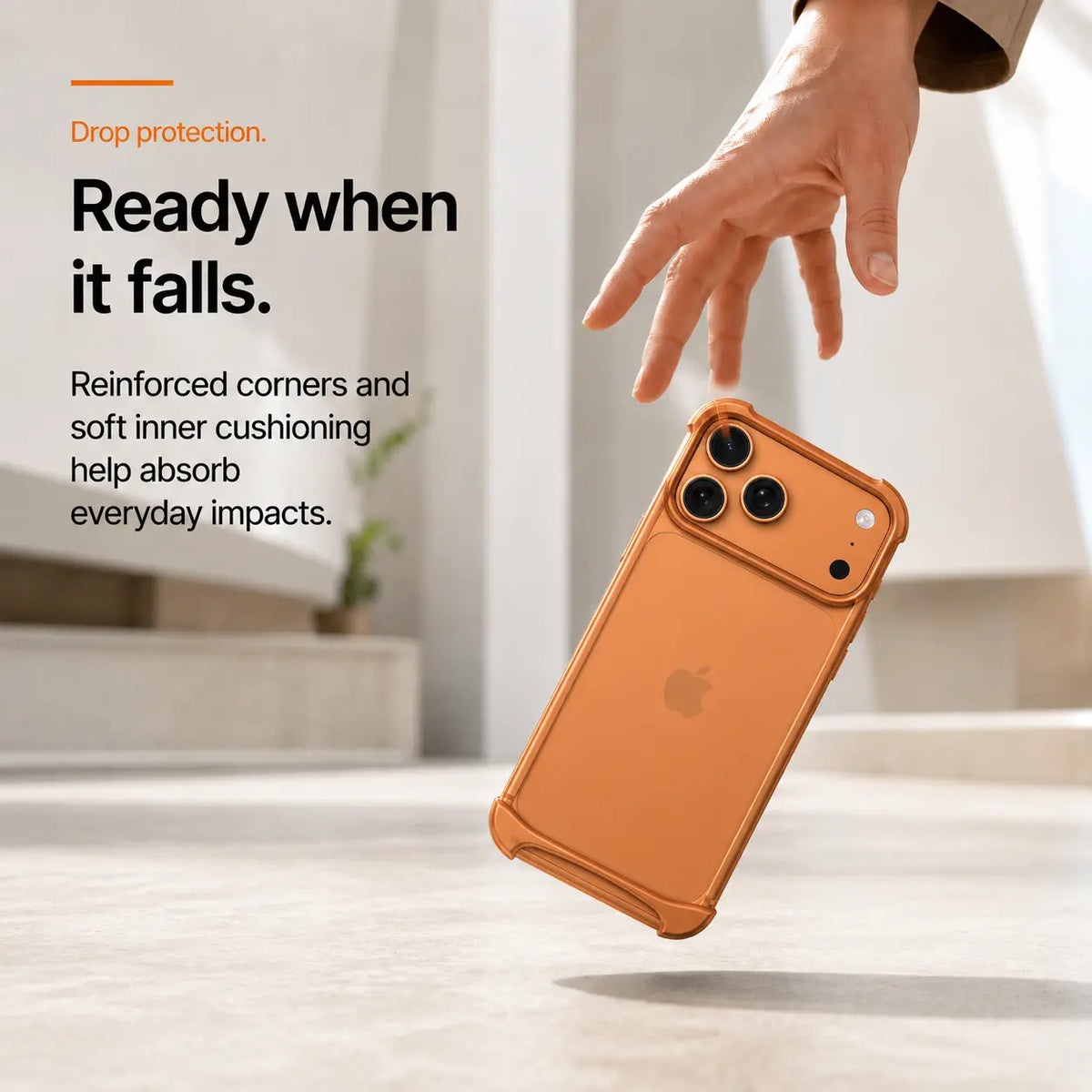 Orange open-back bumper phone case shown during a corner drop demonstration #color_Cosmic Orange